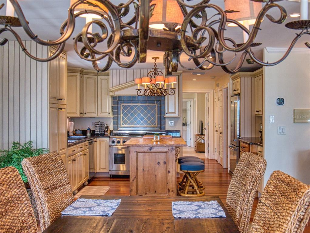 1913 Hill Street, Unit 2 New Smyrna Beach, FL 32169 - Photo 35 of 90 a kitchen with stainless steel appliances granite countertop a stove a sink and a dining table with garden view