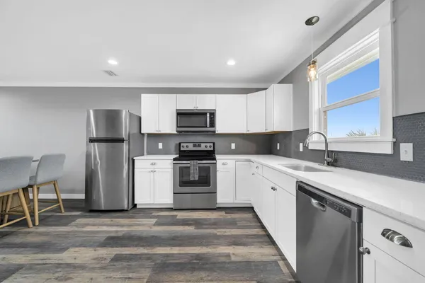 a kitchen with granite countertop a refrigerator stove top oven and sink