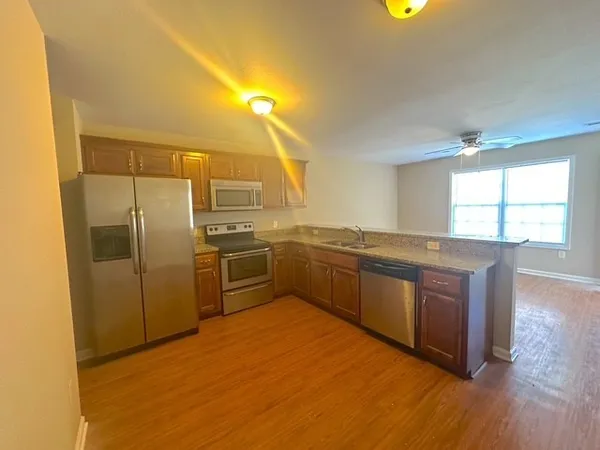 a kitchen with stainless steel appliances granite countertop a sink and a refrigerator