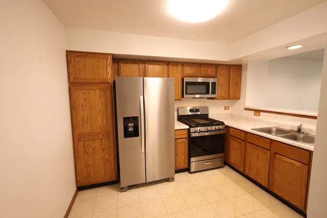 a kitchen with stainless steel appliances granite countertop a refrigerator stove and sink