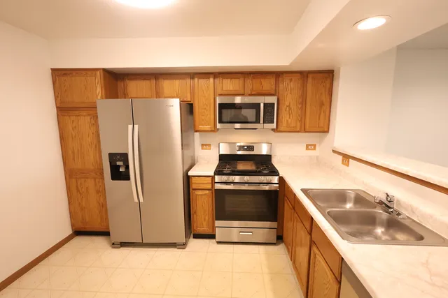 a kitchen with stainless steel appliances granite countertop a refrigerator and a sink