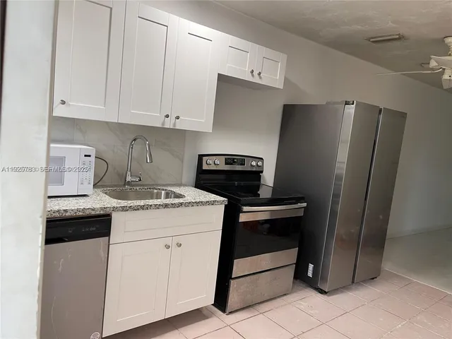 a kitchen with a stove cabinets and refrigerator