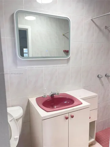 a bathroom with a sink a toilet and a mirror