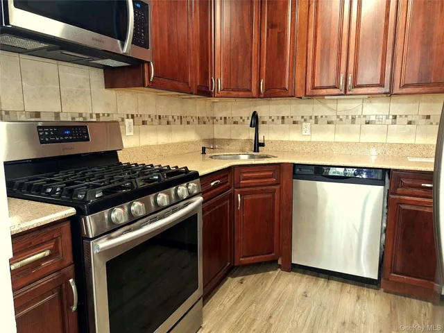 a kitchen with granite countertop wooden cabinets and a stove top oven