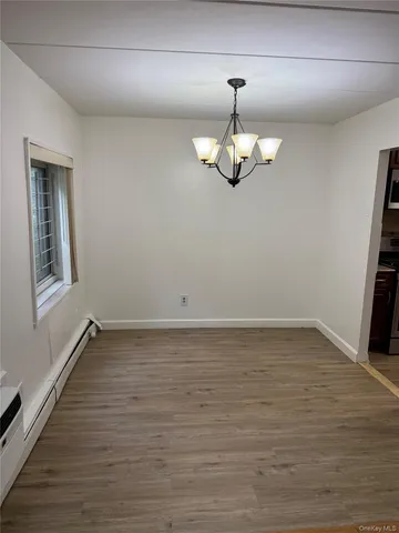 a view of a room with wooden floor and exposed radiator