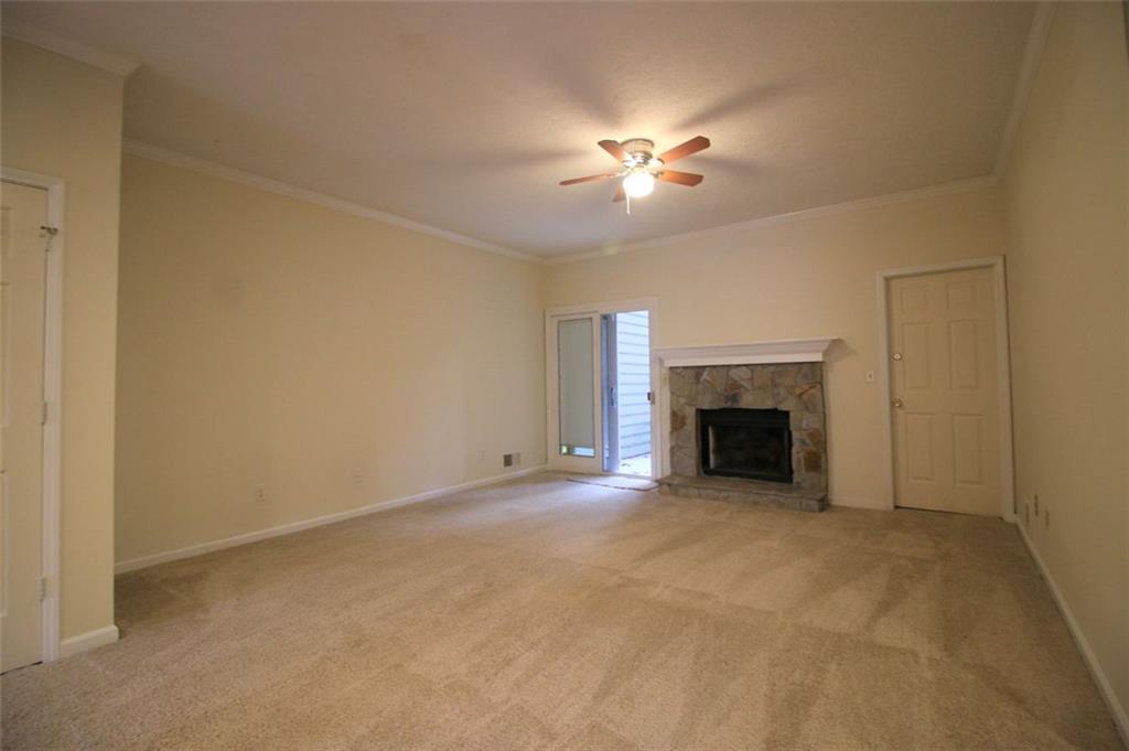 4028 Elm Street Chamblee, GA 30341 - Photo 3 of 13 a view of an empty room with a fireplace and a fan