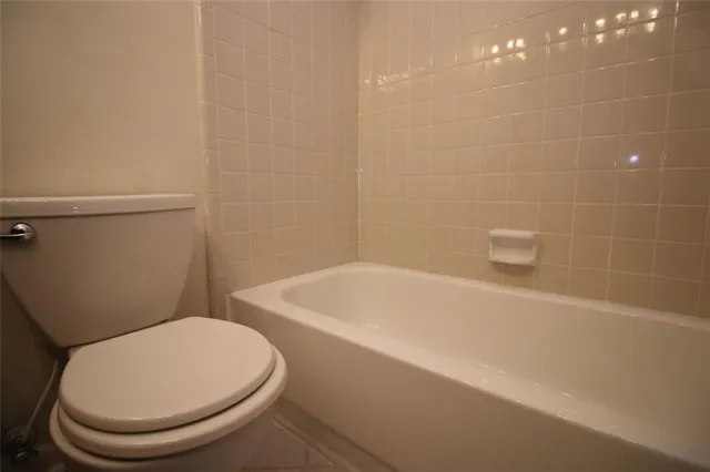 a white toilet sitting next to a bath tub