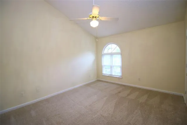 an empty room with a window and a chandelier fan