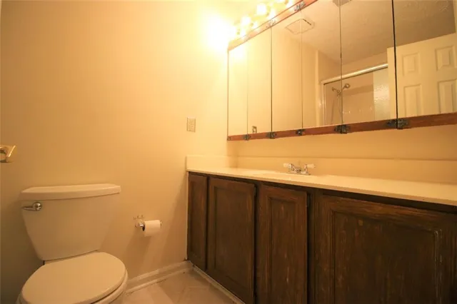 a bathroom with a toilet a sink and mirror