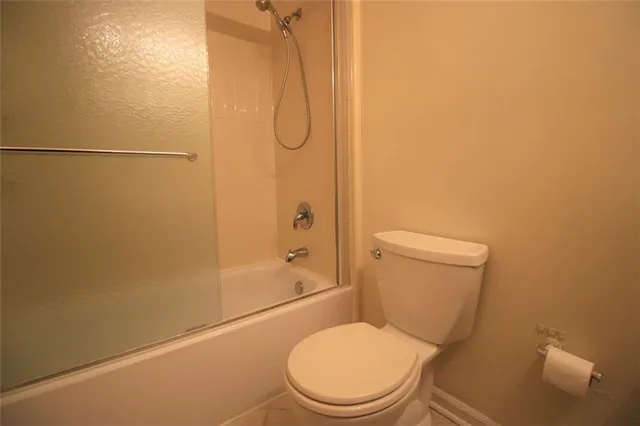 a white toilet sitting next to a bath tub and a shower