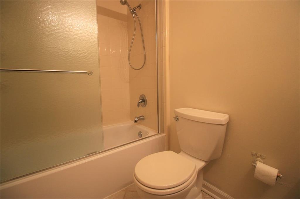 4028 Elm Street Chamblee, GA 30341 - Photo 10 of 13 a white toilet sitting next to a bath tub and a shower