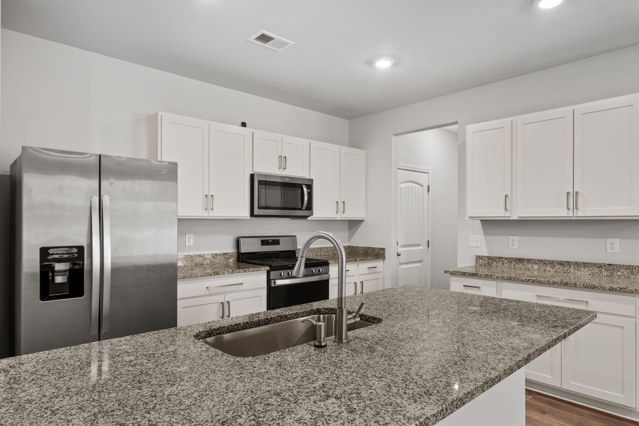 a kitchen with stainless steel appliances granite countertop a sink stove and refrigerator