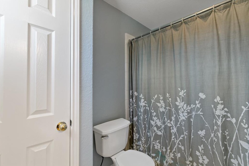 2611 South Breeze Drive Manvel, TX 77578 - Photo 14 of 20 a bathroom with a toilet and shower curtain