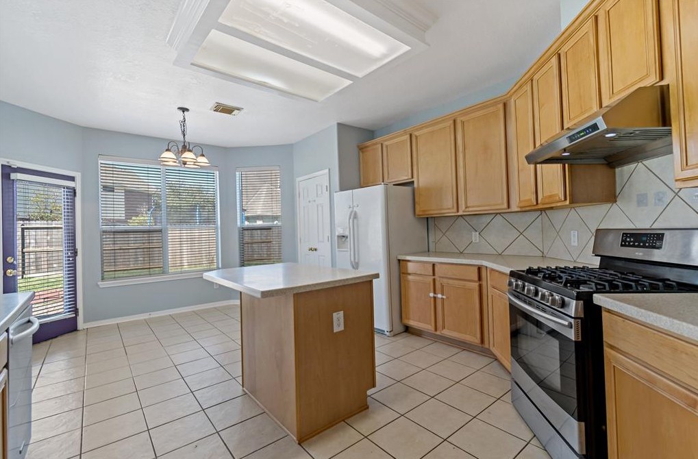 2611 South Breeze Drive Manvel, TX 77578 - Photo 5 of 20 a kitchen with stainless steel appliances granite countertop a stove a sink and a refrigerator