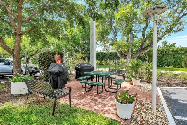 a view of a patio with table and chairs potted plants with large tree