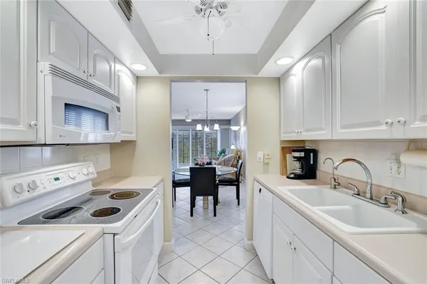 a kitchen that has a sink a stove and cabinets