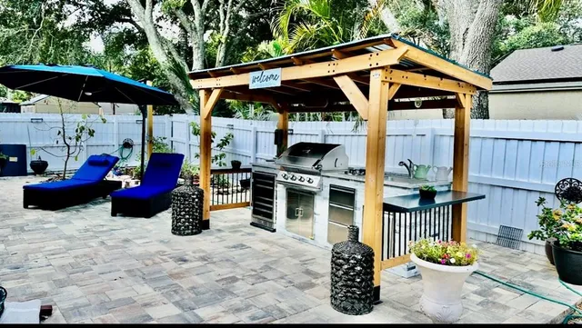 a view of a patio with table and chairs a barbeque