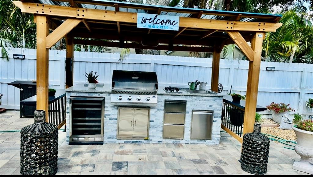 9611 Cypress Brook Road Tampa, FL 33647 - Photo 16 of 16 a view of a patio with table and chairs a barbeque