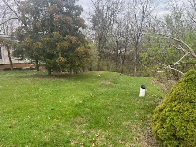 a backyard of a house with lots of green space and fountain