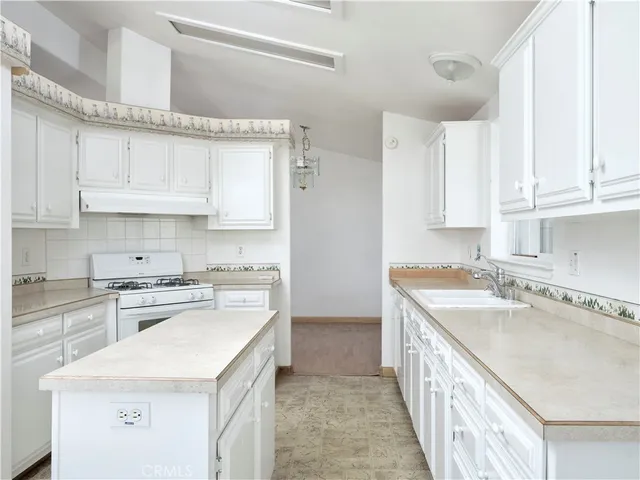 a kitchen with a sink stove top oven and cabinets