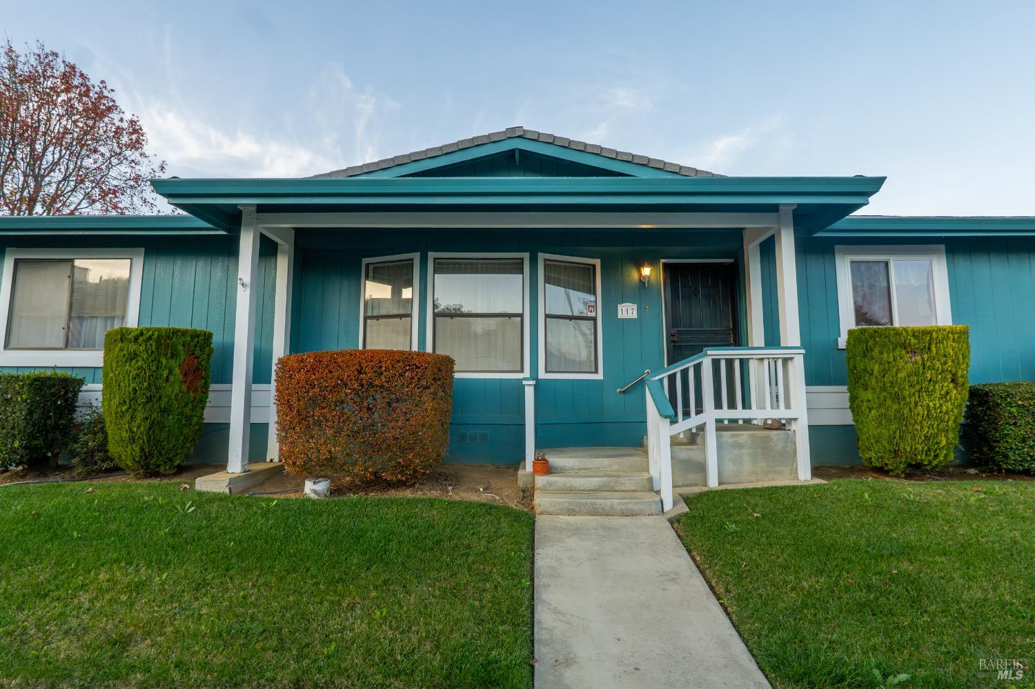 a front view of a house with a garden and plants
