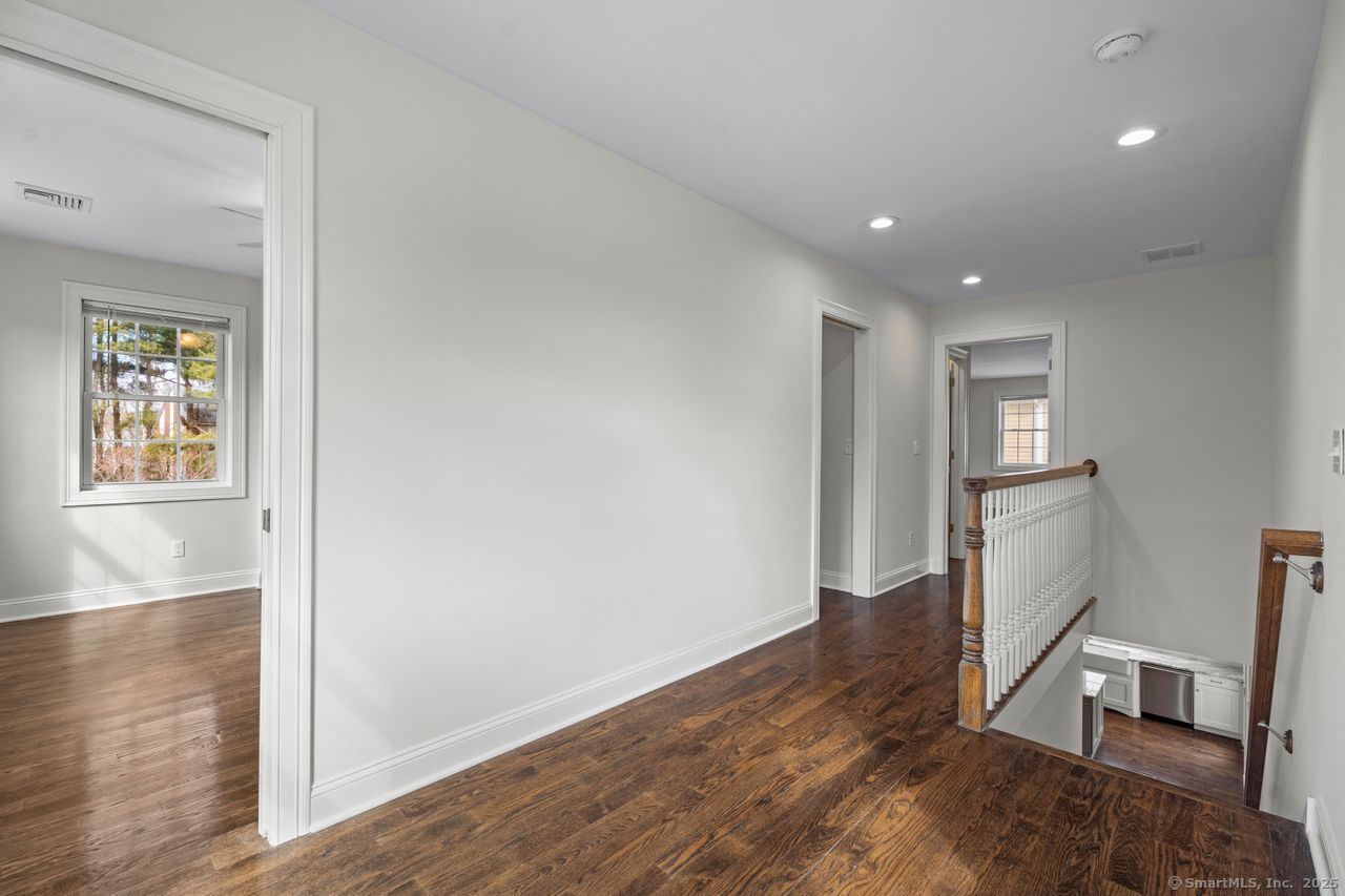 67 Boston Post Road, Unit 8 Madison, CT 06443 - Photo 19 of 35 Second floor hallway with guest bedroom to the left and primary bedroom in the distance