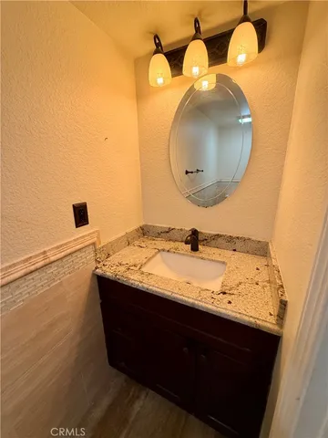 a bathroom with a granite countertop sink and a mirror
