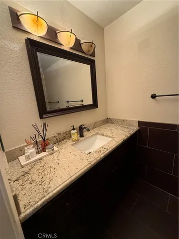 a bathroom with a sink vanity and a granite island