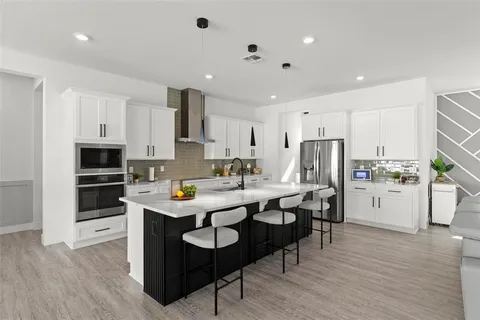 a kitchen with stainless steel appliances a sink stove top oven and refrigerator