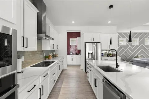 a kitchen with stainless steel appliances a sink a stove a refrigerator and cabinets