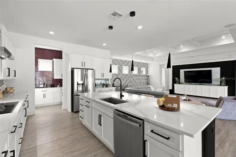 a kitchen with a sink a refrigerator and cabinets