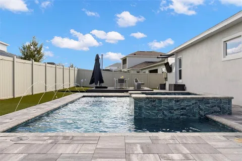 a view of a house with backyard and sitting area
