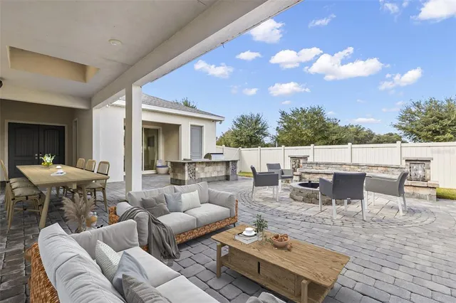 a view of a patio with couches and dining table with garden view
