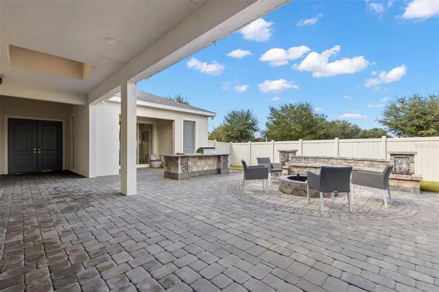 a view of a patio with dining table and chairs with wooden floor and fence