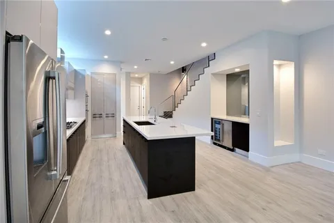 a kitchen with kitchen island a sink and wooden floor