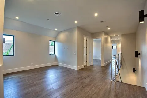 a view of hallway with a window and wooden floor