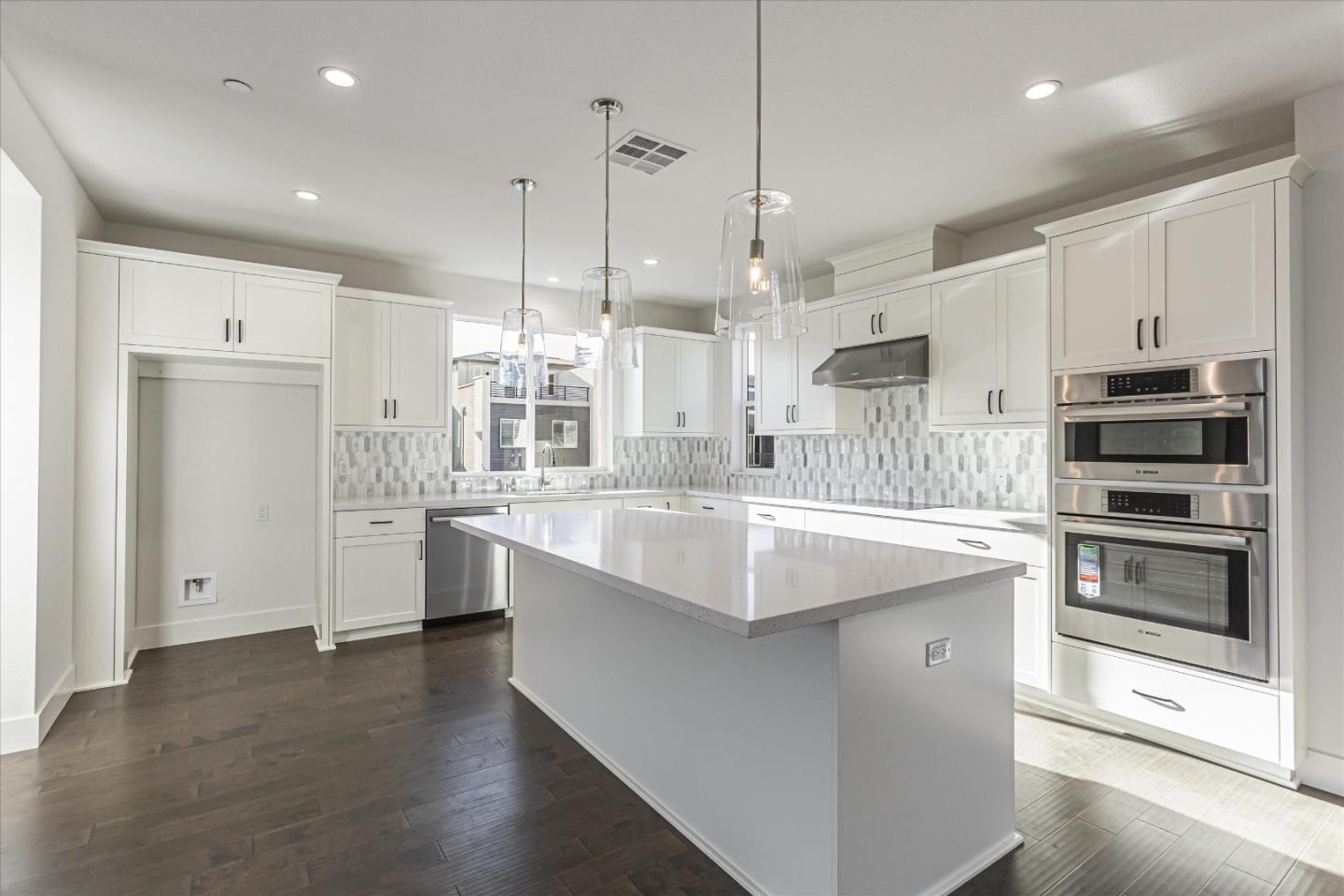 6008 Sunglow Terrace San Ramon, CA 94583 - Photo 5 of 23 a large kitchen with kitchen island a stove a sink a refrigerator and white cabinets with wooden floor