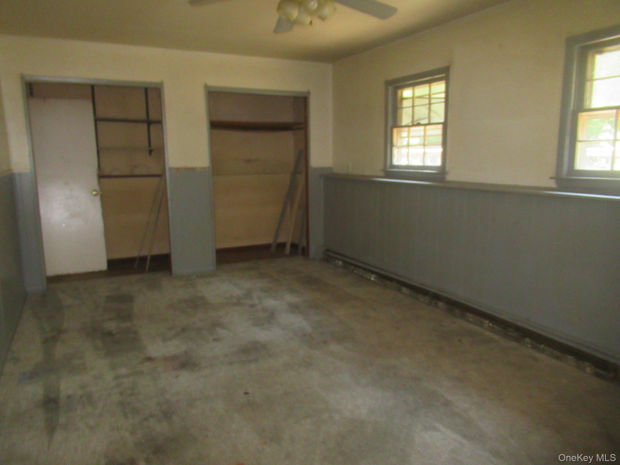 24 Edinburgh Road Middletown, NY 10941 - Photo 17 of 17 Unfurnished bedroom with a wainscoted wall, multiple closets, multiple windows, carpet, and a ceiling fan
