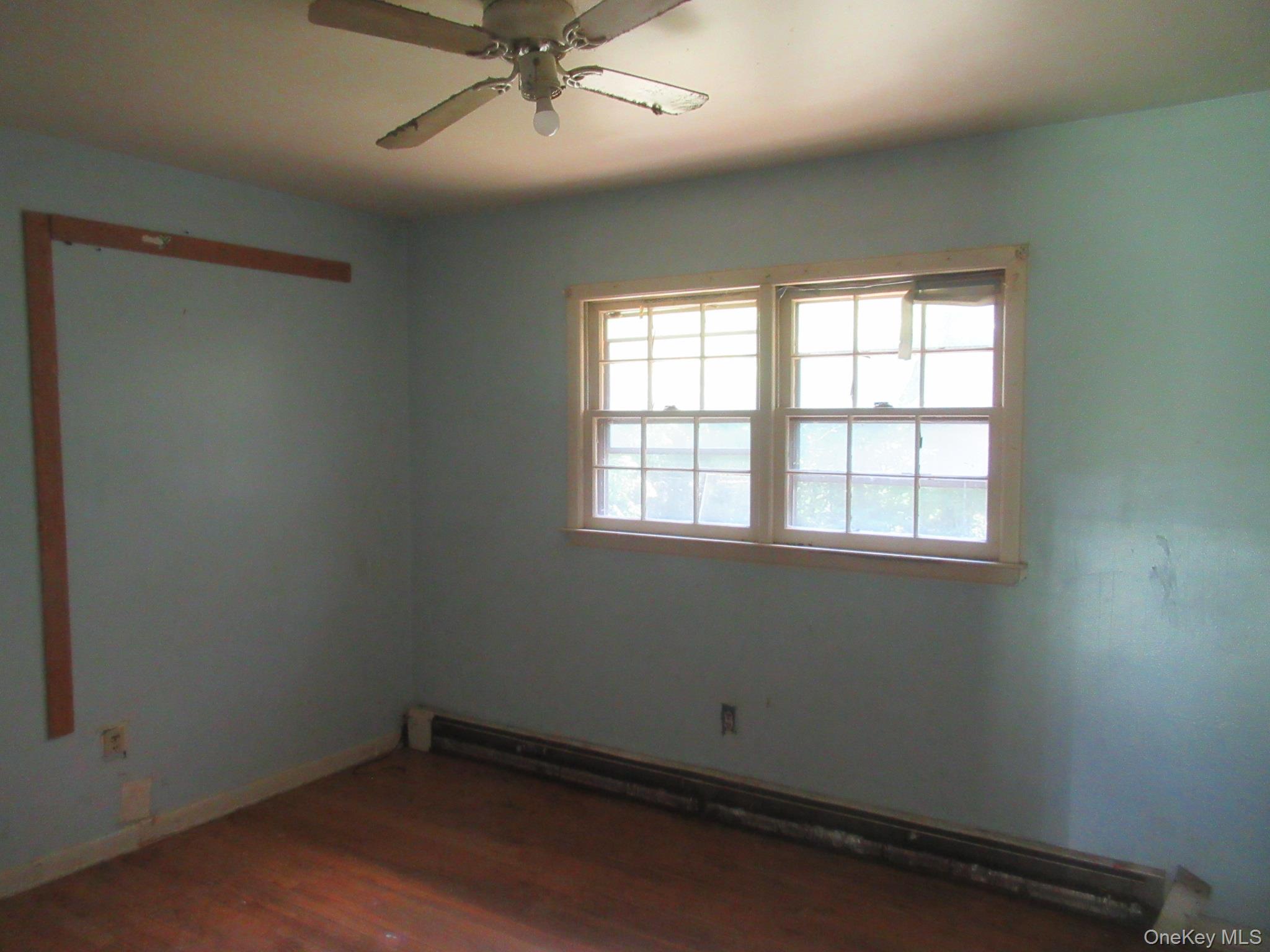 24 Edinburgh Road Middletown, NY 10941 - Photo 9 of 17 Empty room featuring a baseboard radiator, wood finished floors, and ceiling fan