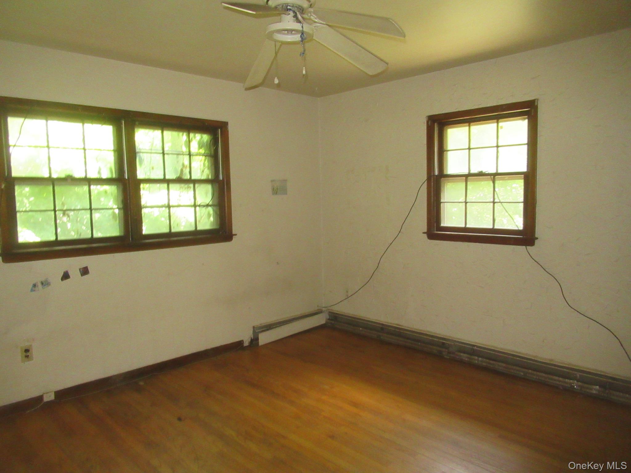 24 Edinburgh Road Middletown, NY 10941 - Photo 10 of 17 Unfurnished room featuring wood finished floors, ceiling fan, and a baseboard heating unit