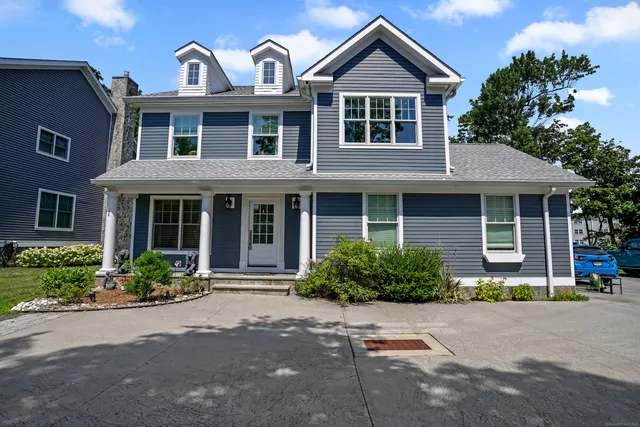 a front view of a house with a yard and outdoor seating
