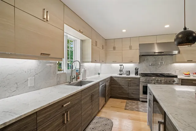 a kitchen with stainless steel appliances granite countertop a sink a stove and a refrigerator
