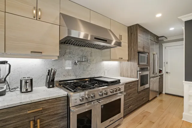 a kitchen with stainless steel appliances granite countertop a stove and a refrigerator
