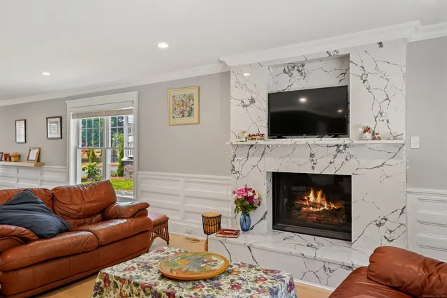 a living room with furniture a flat screen tv and a fireplace