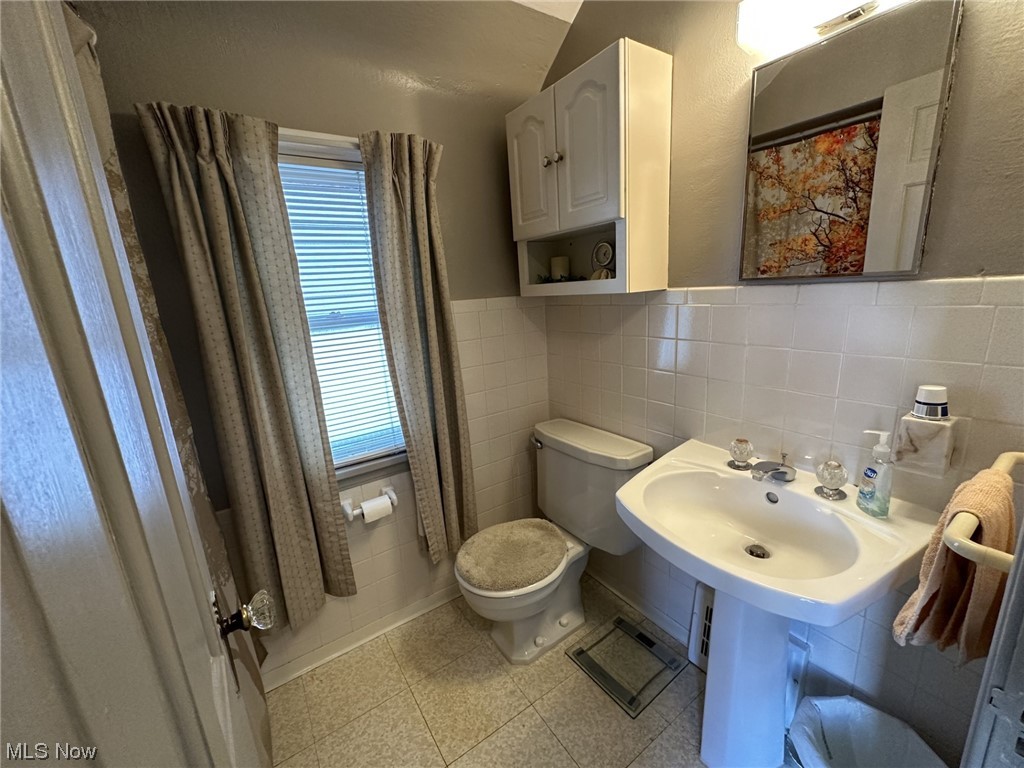 14422 Alger Road Cleveland, OH 44111 - Photo 11 of 16 Bathroom featuring sink, tile walls, tile flooring, tasteful backsplash, and toilet