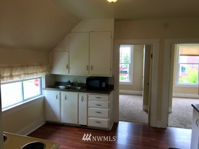 2402 Rucker Avenue Everett, WA 98201 - Photo 13 of 22 a kitchen with stainless steel appliances a kitchen island a stove a wooden floor and a window