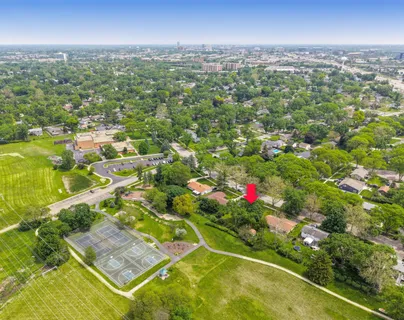 an aerial view of residential houses with outdoor space and trees