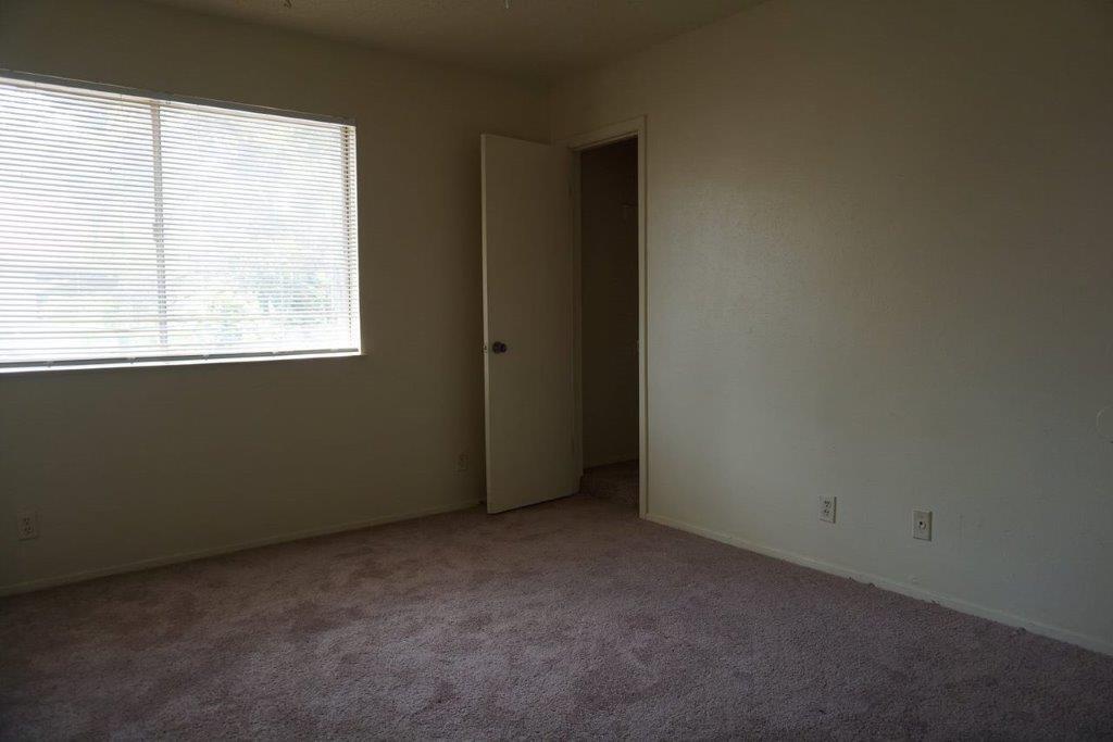 5919 Hidden Valley Trail Austin, TX 78744 - Photo 7 of 8 A spacious room awaits personalization, featuring a large window for ample natural light and plush carpeting.