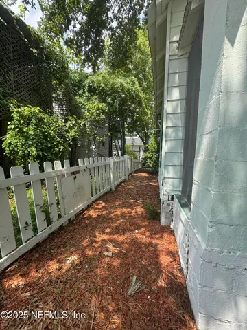 a view of a yard with wooden fence