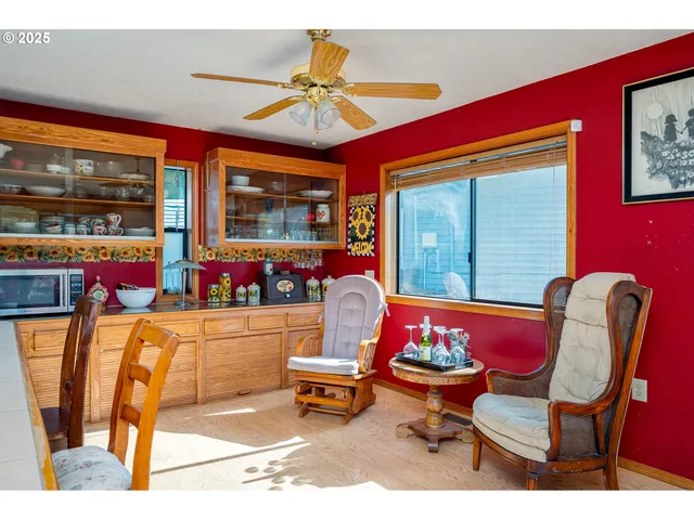 a living room with furniture a flat screen tv and floor to ceiling window